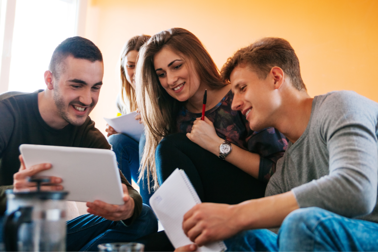 Young adults looking at tablet and smiling