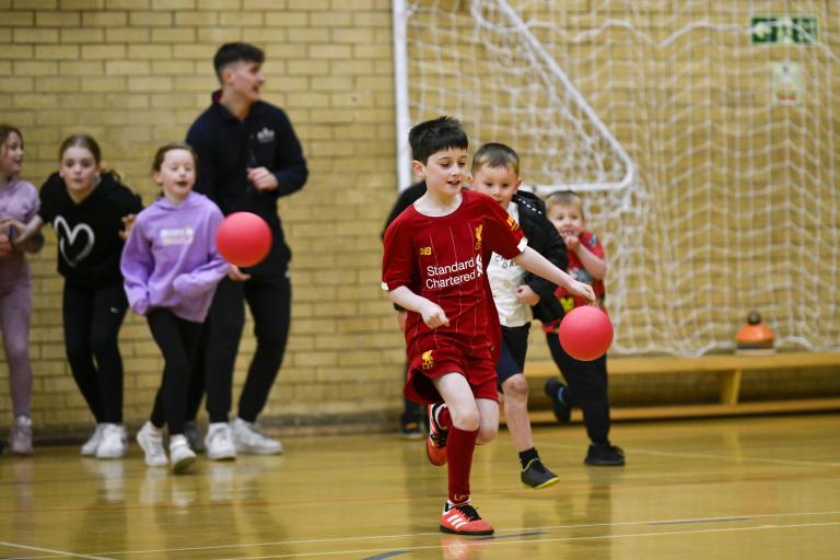 Children playing ball games in a sports hall