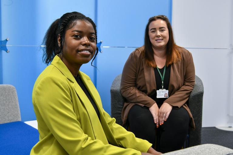 Seated staff members smiling towards camera