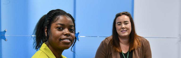 Seated staff members smiling towards camera